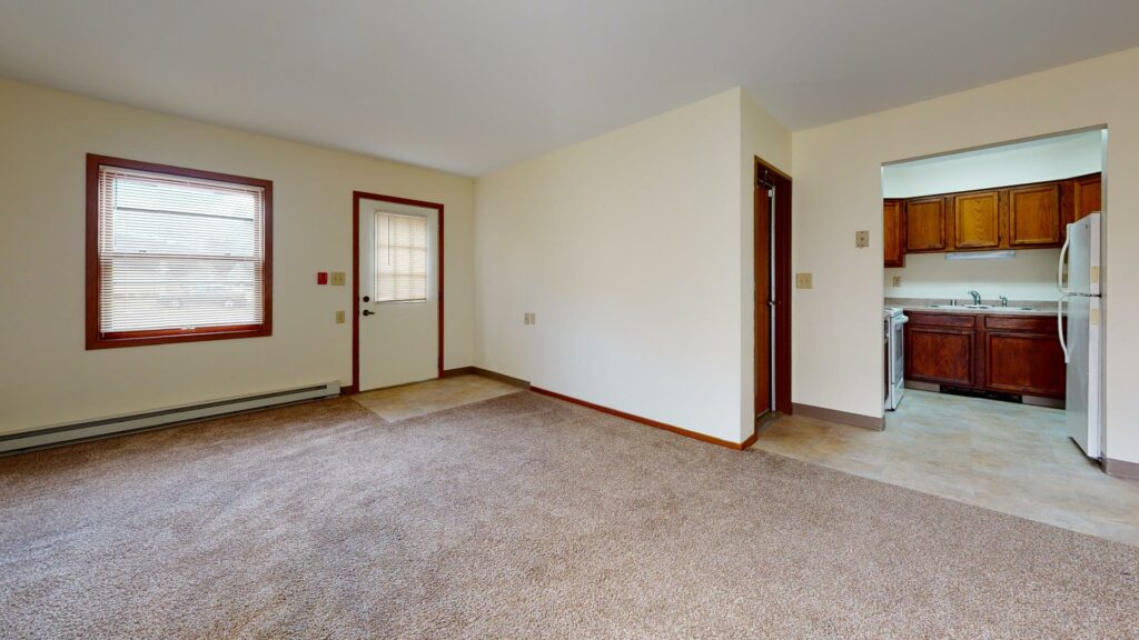 carpeted living area with kitchen attached