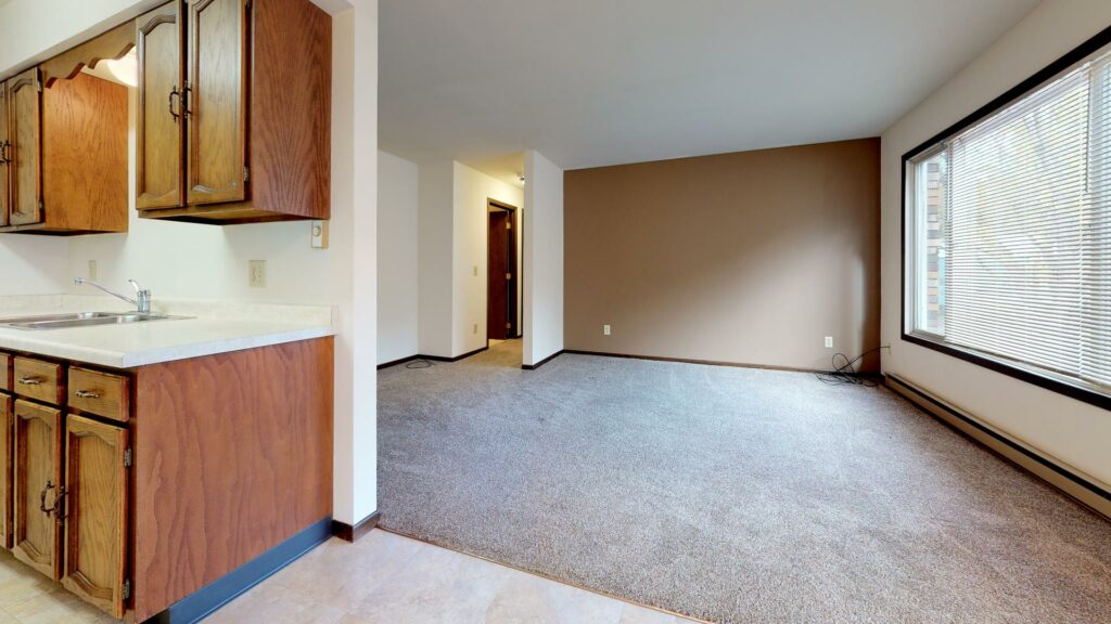 kitchen connected to carpeted living area